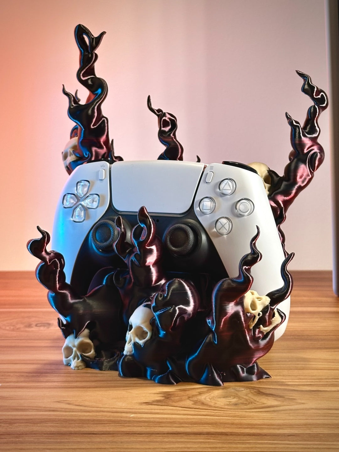 Close view of a black and blue skull flame controller holder displayed with a white and black game controller