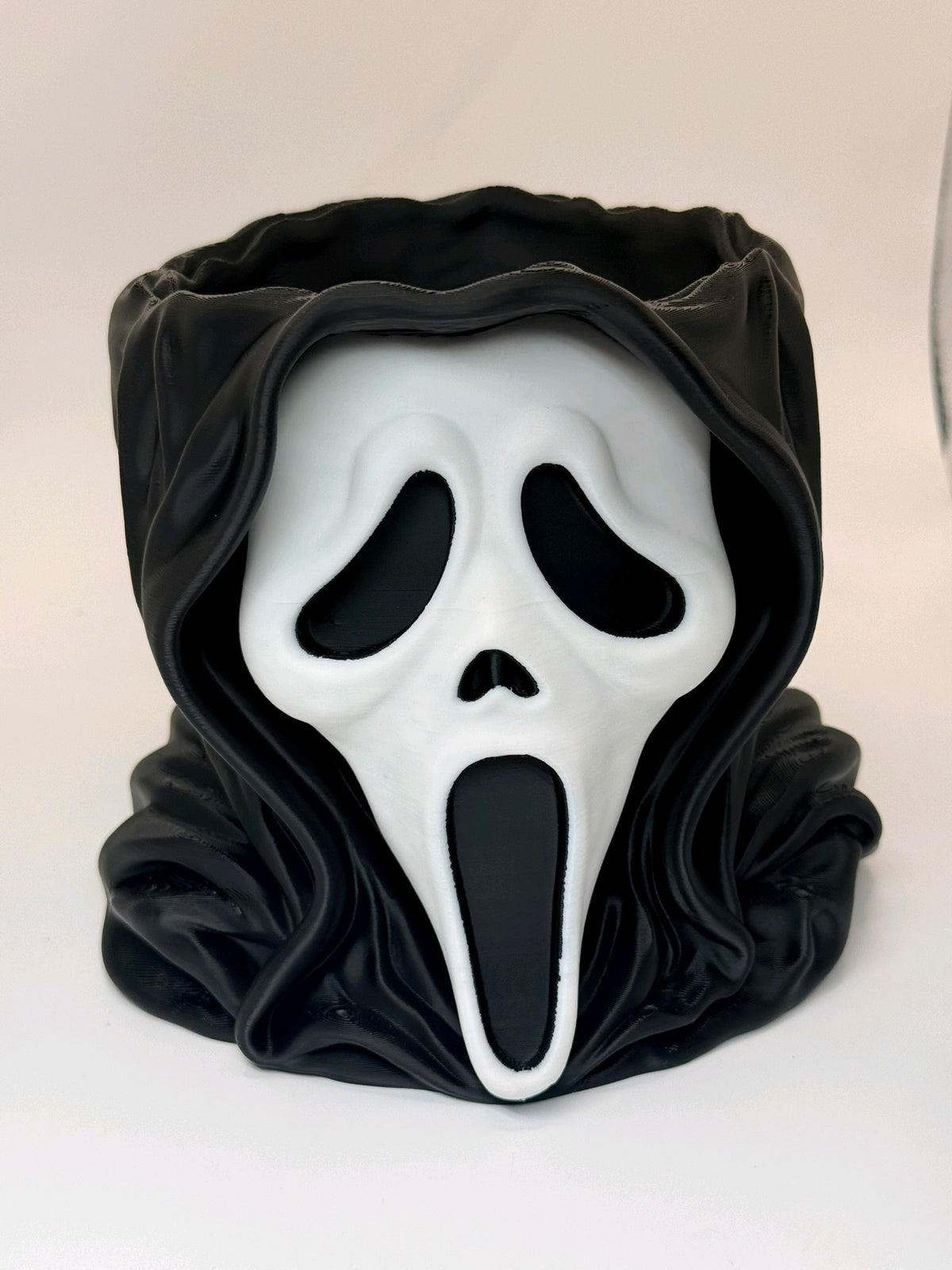 Black and white Ghostface-inspired head bowl filled with wrapped Halloween sweets