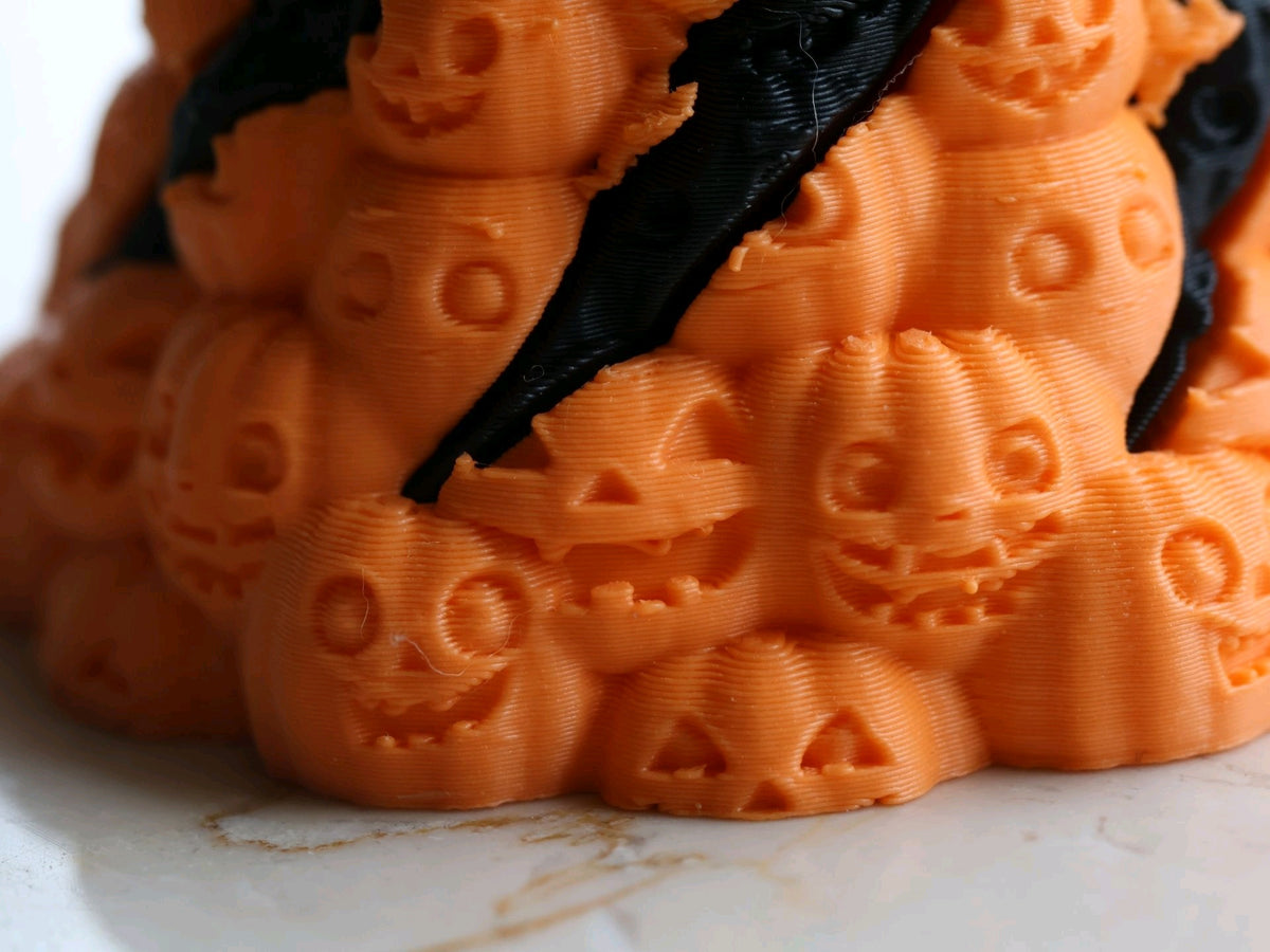 Close-up of orange skull faces and black spiral bands on Skull Mountain fidget