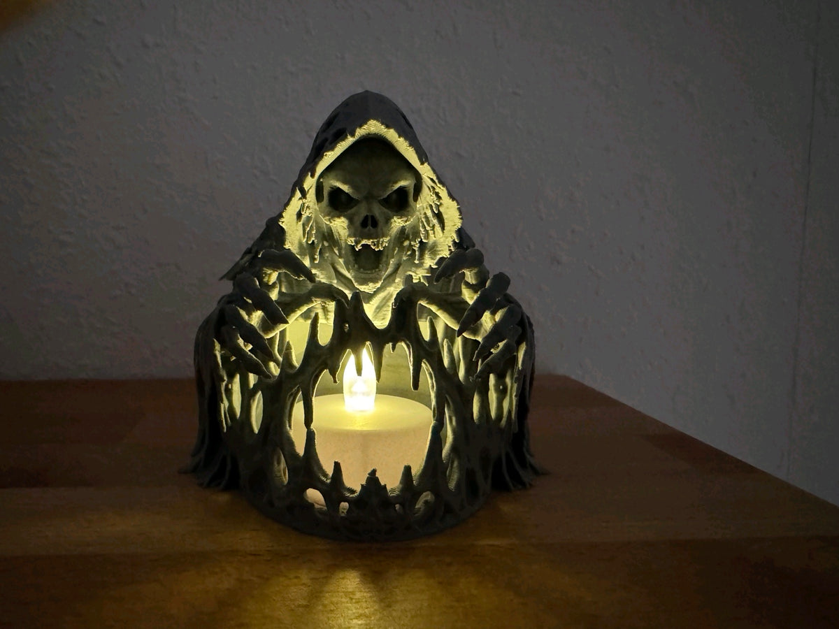 Black skeleton over a tealight holder glowing on a dark wooden table