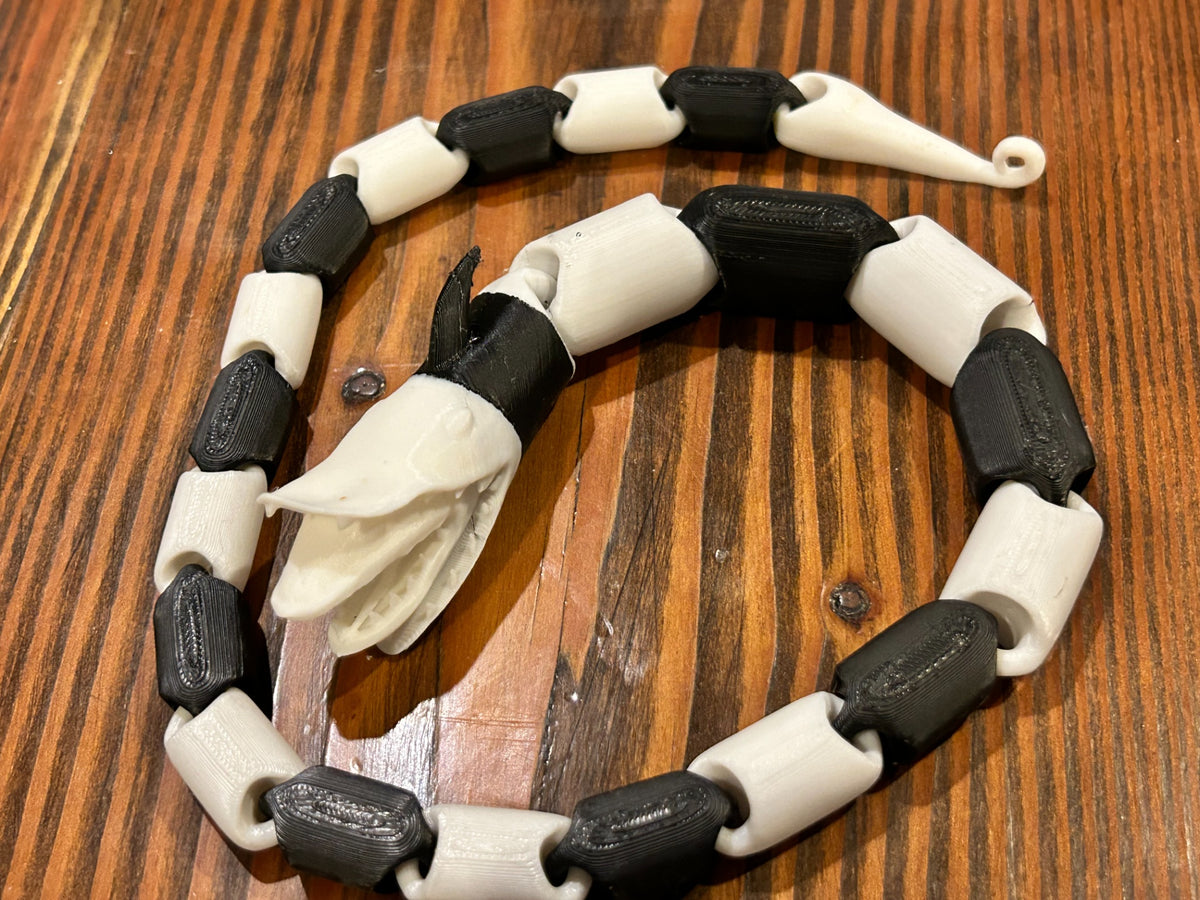 Long black and white articulated snake fidget toy with character head