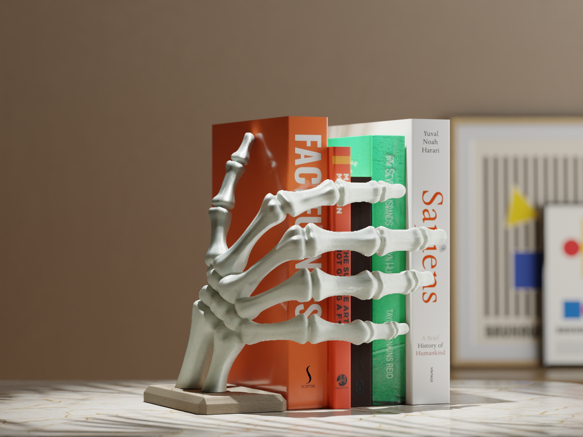 Pair of unpainted skeleton hand book holders gripping a row of books