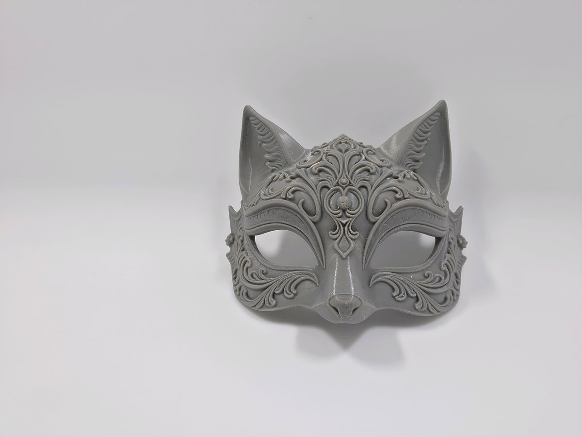 Metallic grey ornate cat mask with pointed ears and raised scrollwork shown from the side