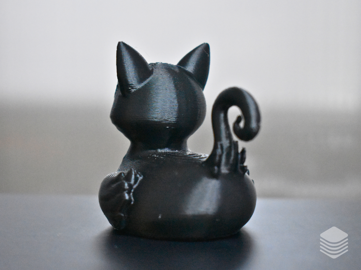 Rear view of the black cat bath duck showing pointed ears, wings and curled tail