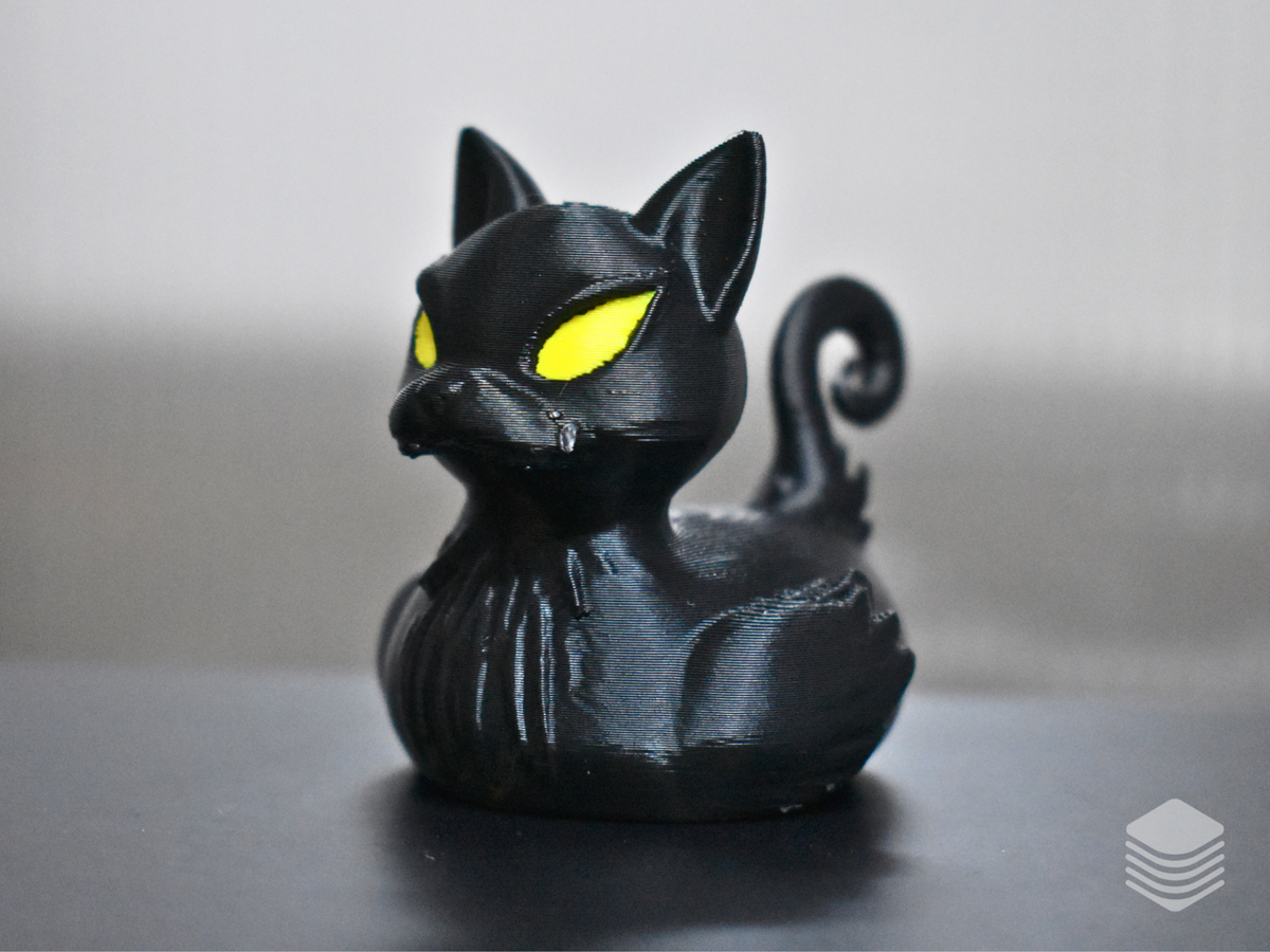 Front view of the glossy black cat bath duck with yellow eyes and small fangs