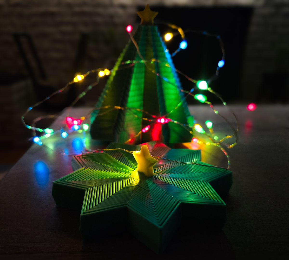 Star-shaped fidget spinner shown in a hand among colourful festive lights