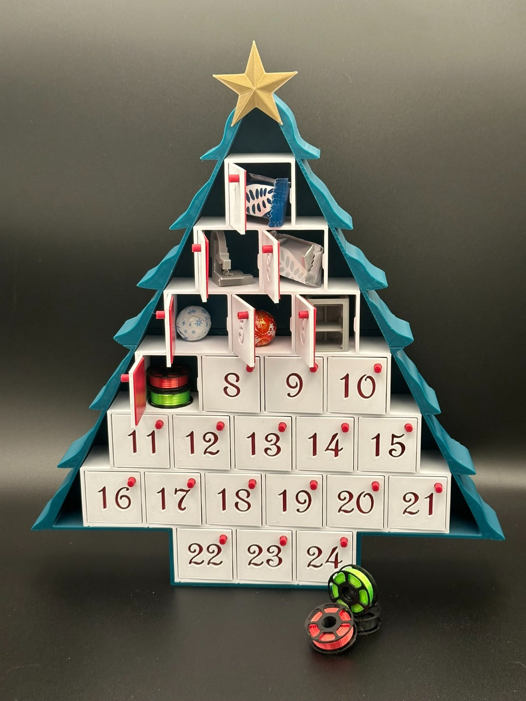 Two tree-shaped Advent calendars with numbered drawers and star toppers
