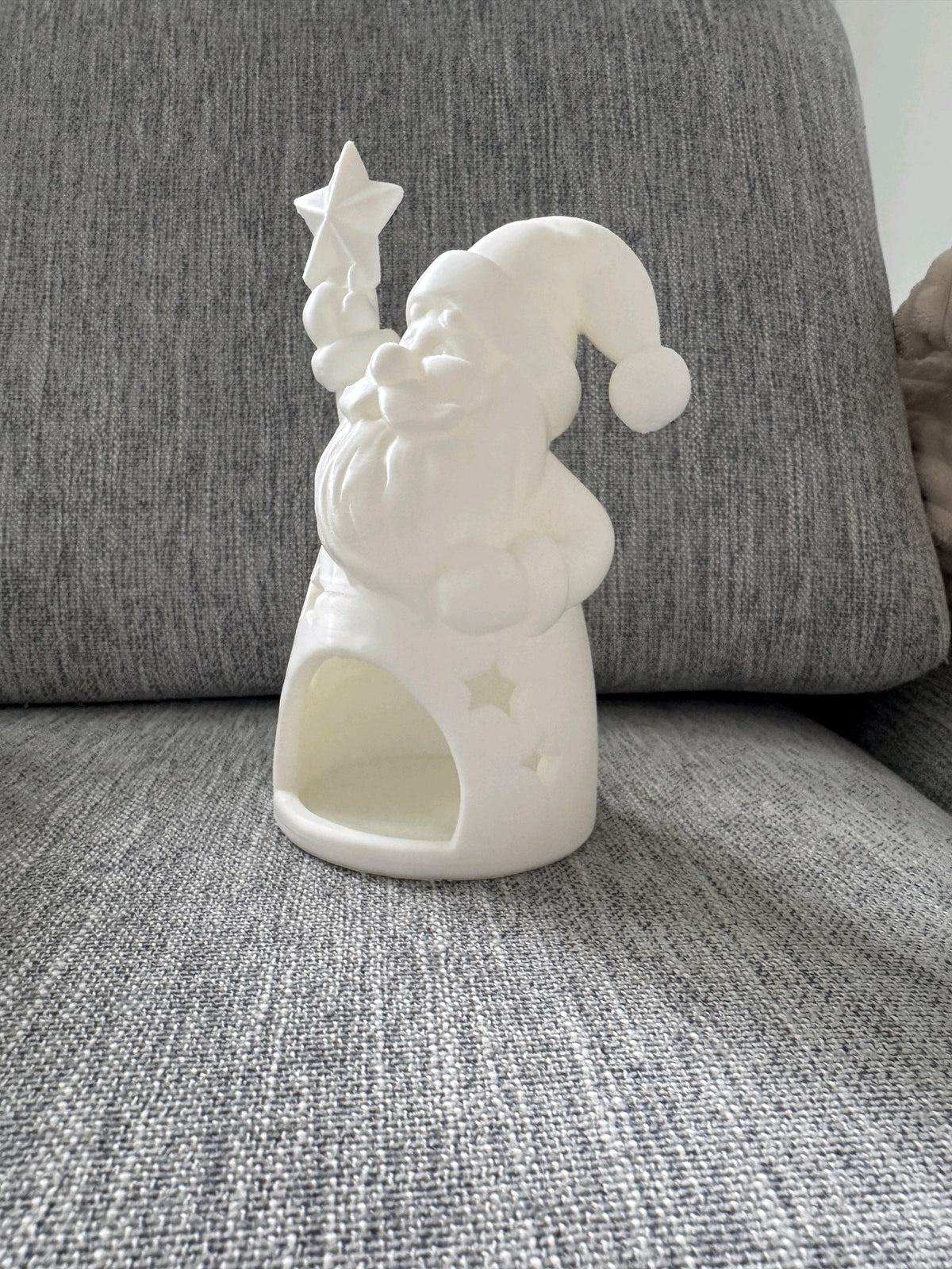 Blue bearded Santa tealight holder with star details and a glowing tealight opening