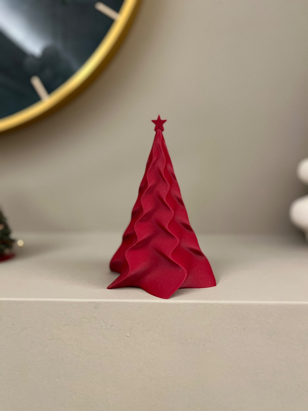 Red and white colour examples of the sculpted Christmas tree decorations displayed on a shelf