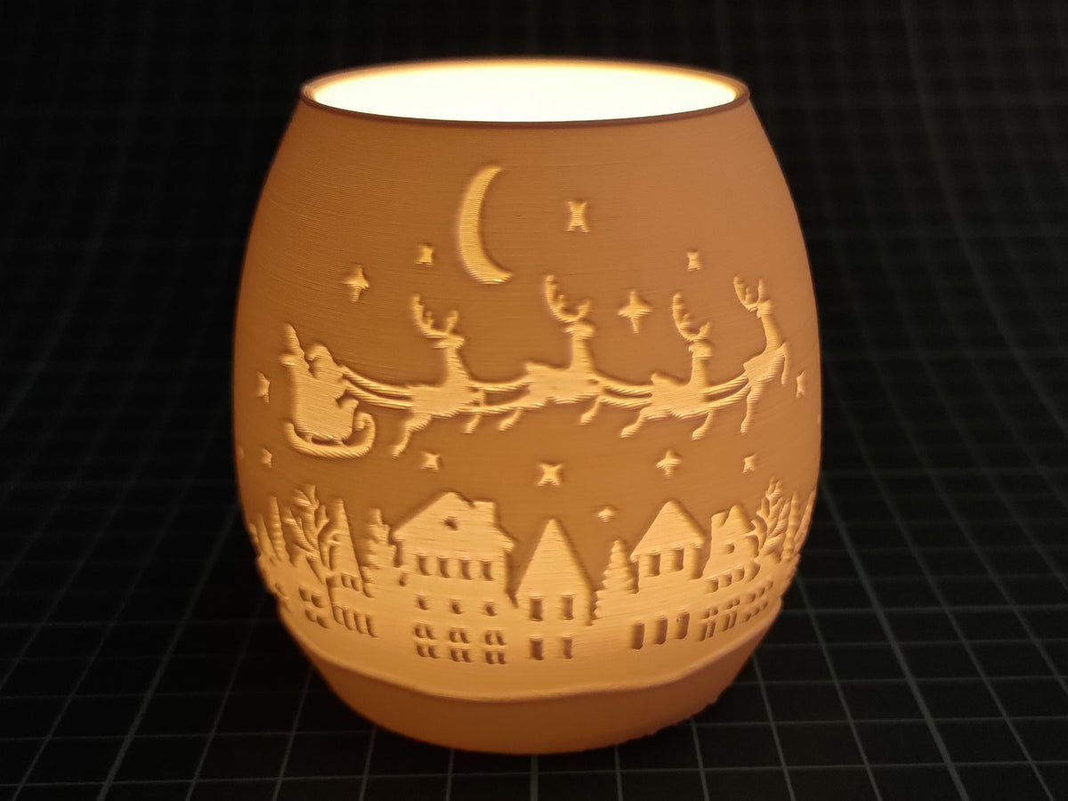 Close view of the amber holder's Santa sleigh, crescent moon, stars and winter village design