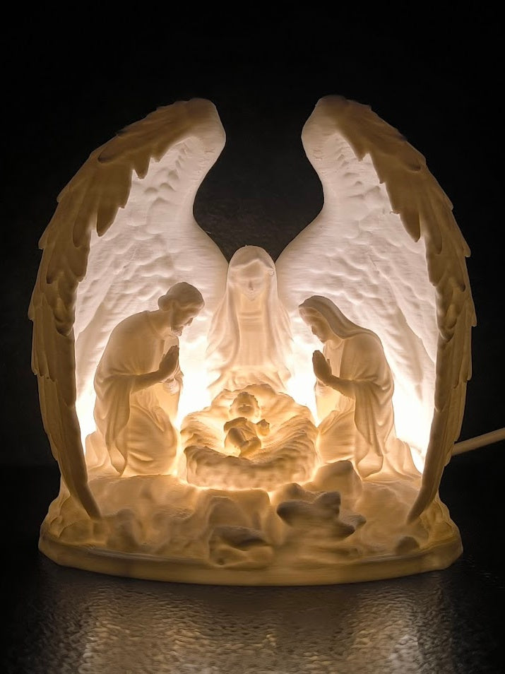 Nativity scene with Mary, Joseph and baby Jesus framed by sculpted wings