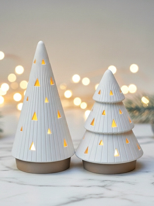 Two ribbed Christmas tree tealight holders with triangular openings and fixed beige bases, glowing warmly