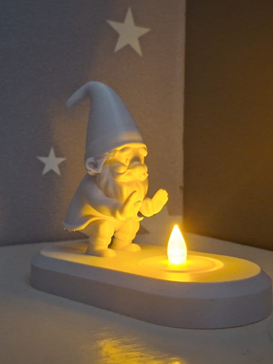 Blue Santa figure with raised hand standing behind the tealight recess on an oval base