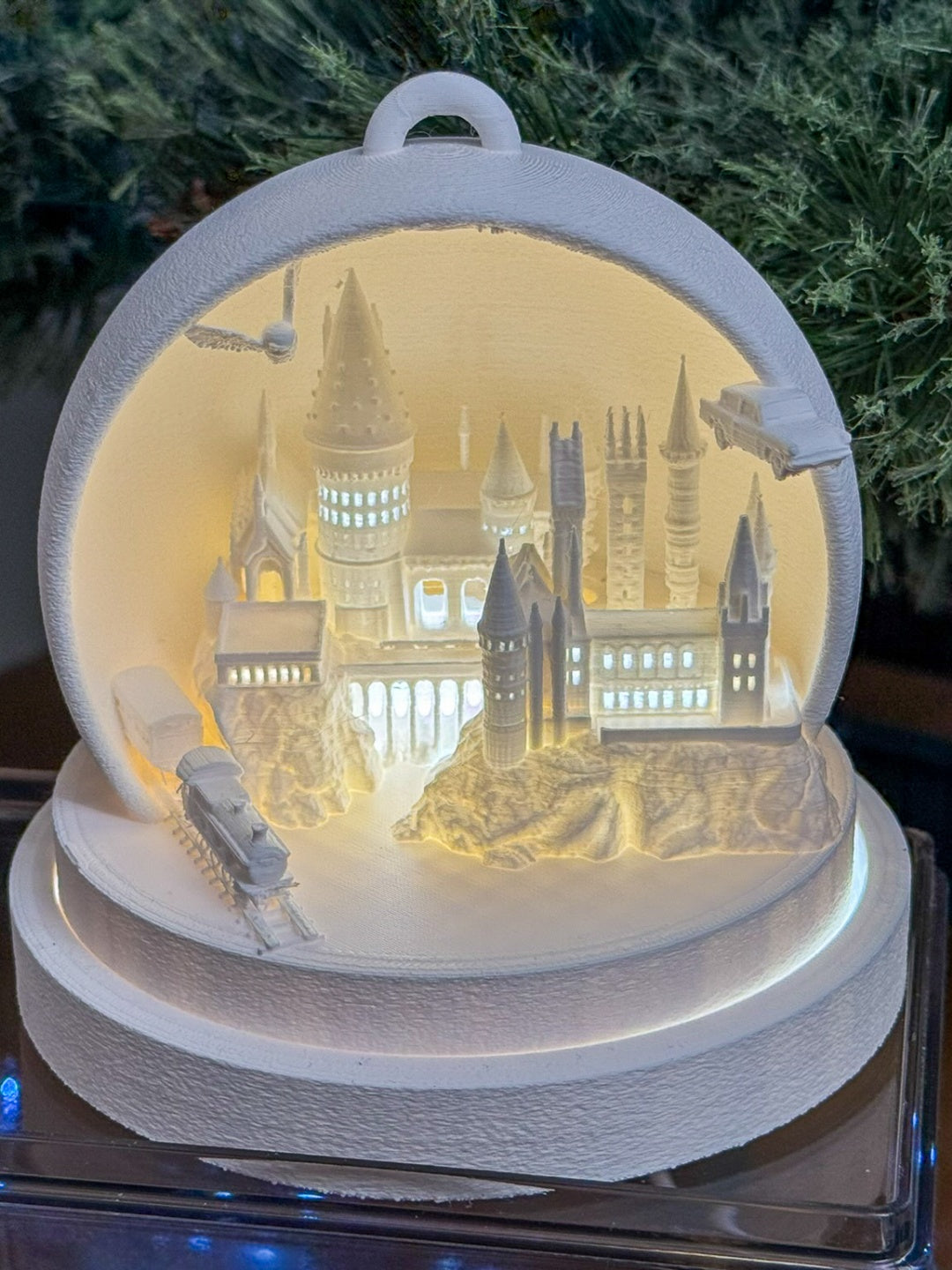 White rounded cathedral tealight holder with illuminated spires and miniature train