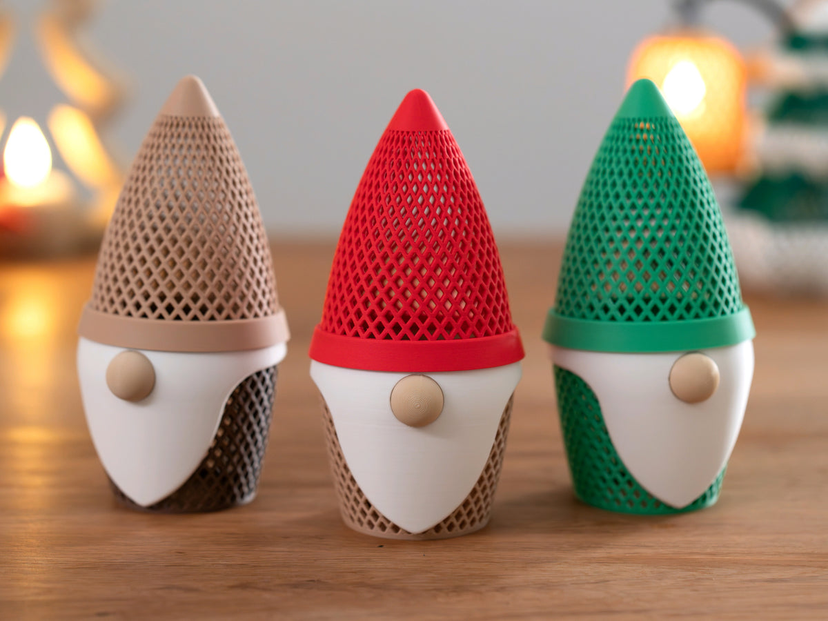 Front view of three gonk tealight holders in beige, red and green with lattice hats and white beards