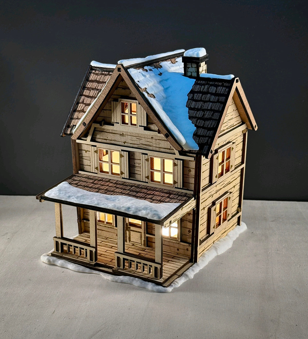 Alternate view of the snowy Tealight House showing its porch and warm windows