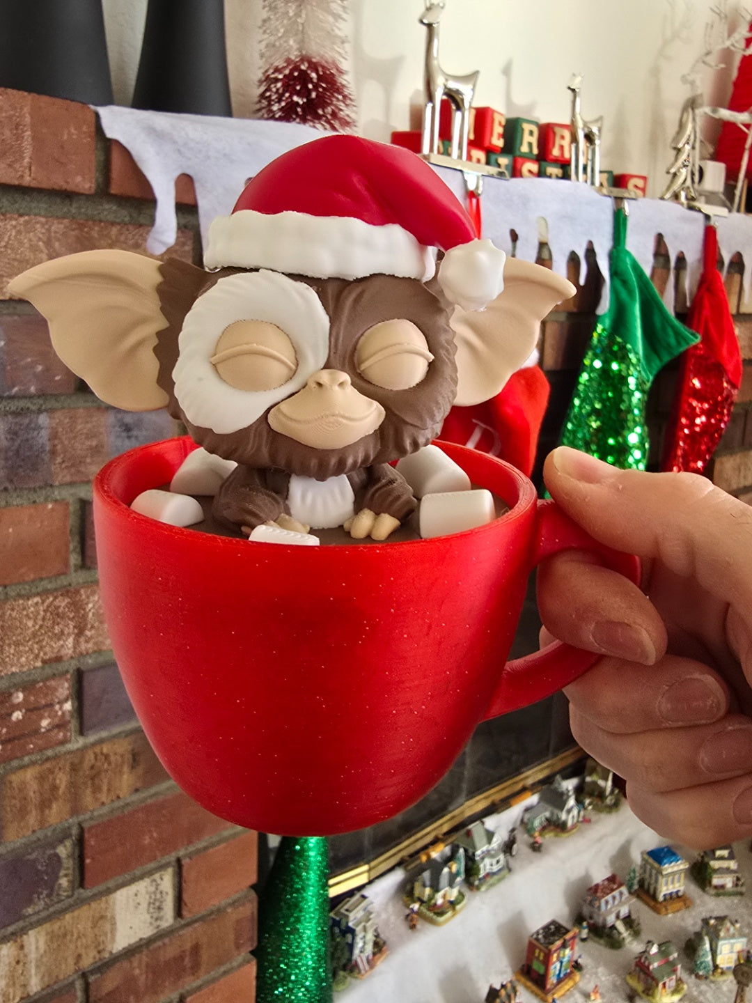 Gizmo Christmas ornament in a red mug, wearing a Santa hat