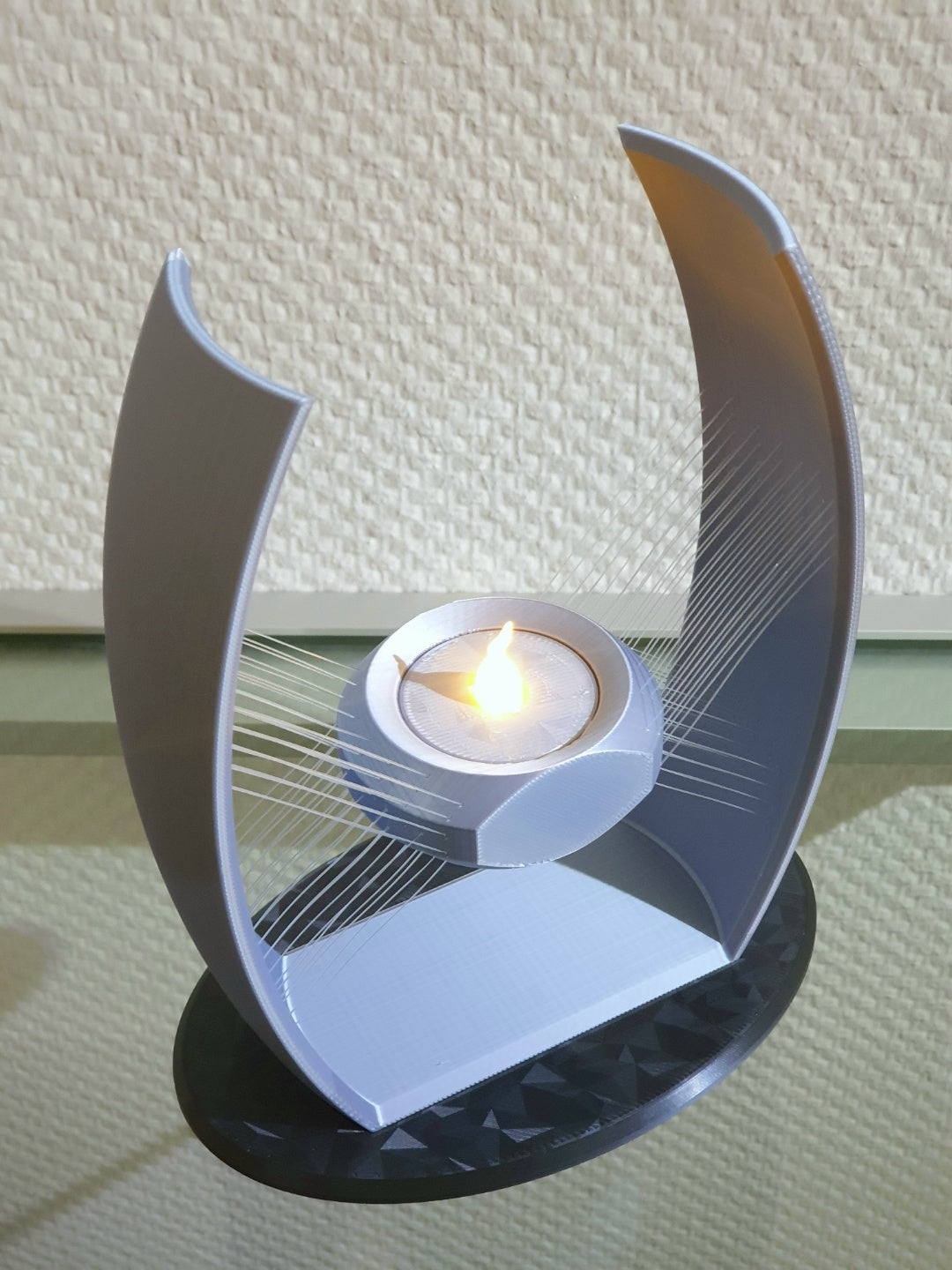 Angled view of the suspended tealight holder on its black base