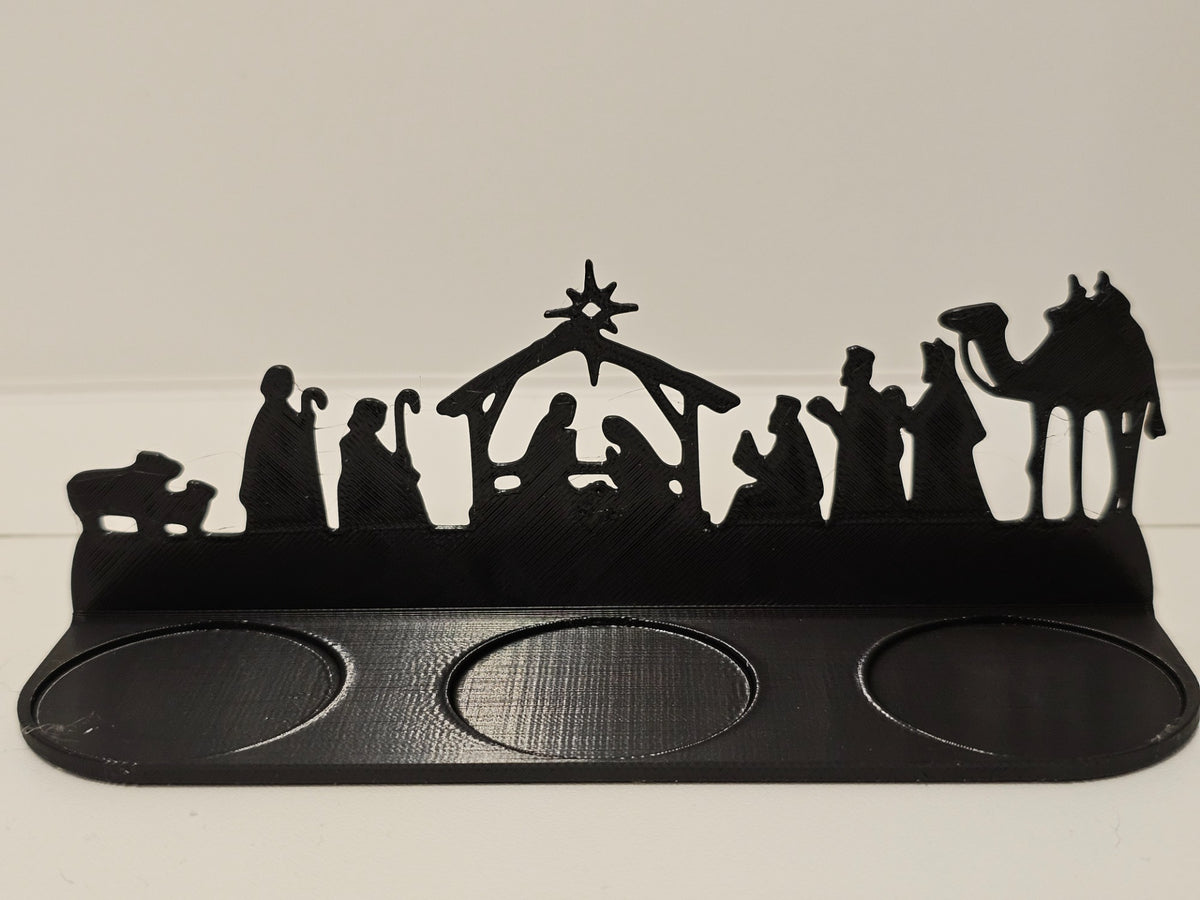 Black Nativity scene tealight holder with star, stable, figures, camel and three round tealight recesses.
