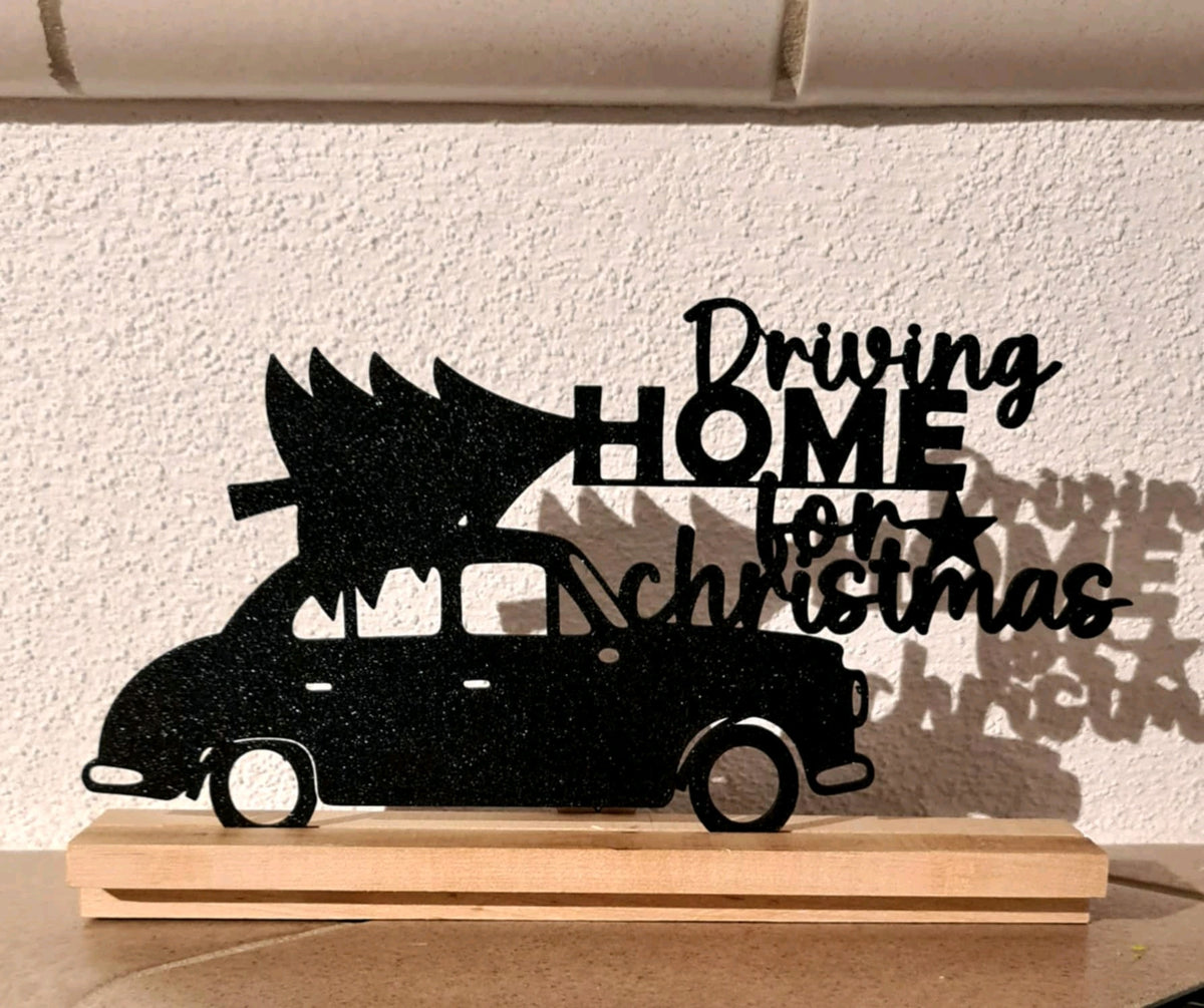 Freestanding black Driving Home for Christmas car silhouette sign on a natural wood base