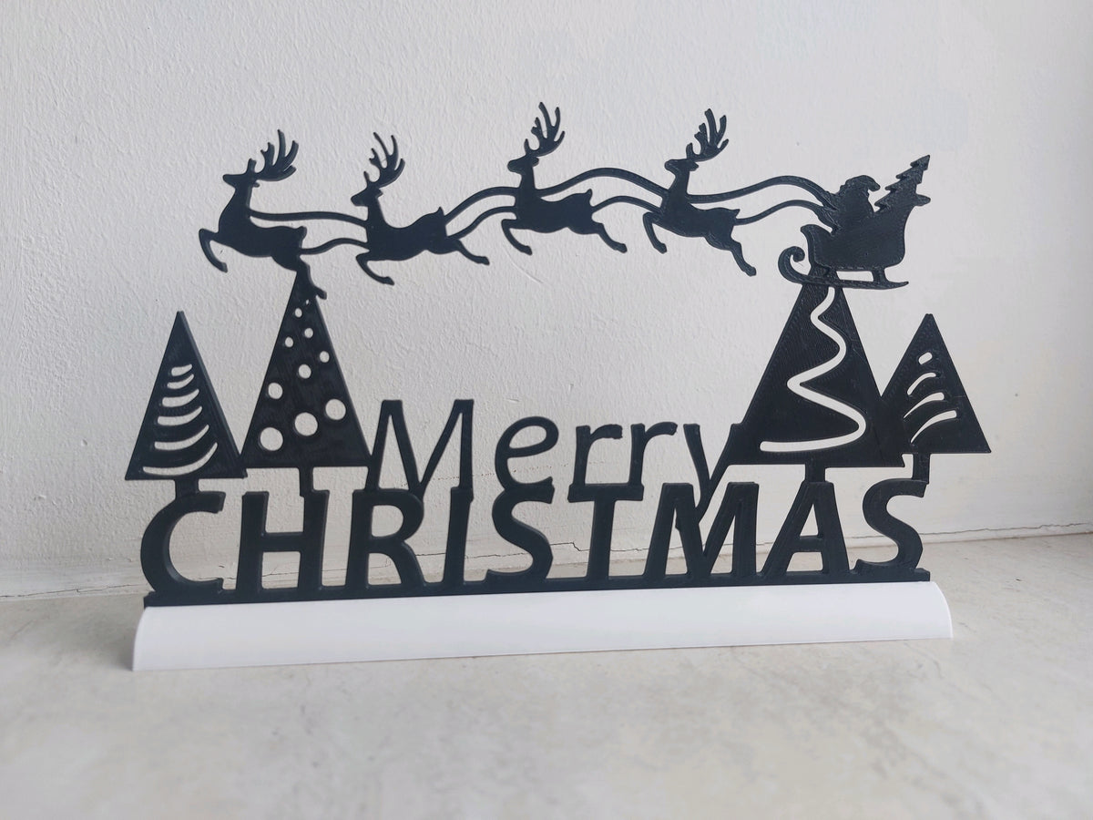 Black Merry Christmas sign with Santa's sleigh, four reindeer and trees on a fixed white base