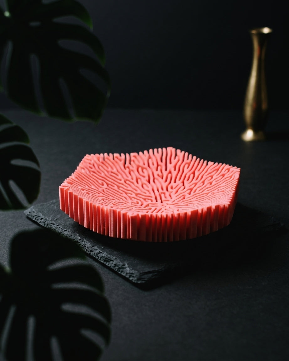 Pink coral bowl on travertine and greenery