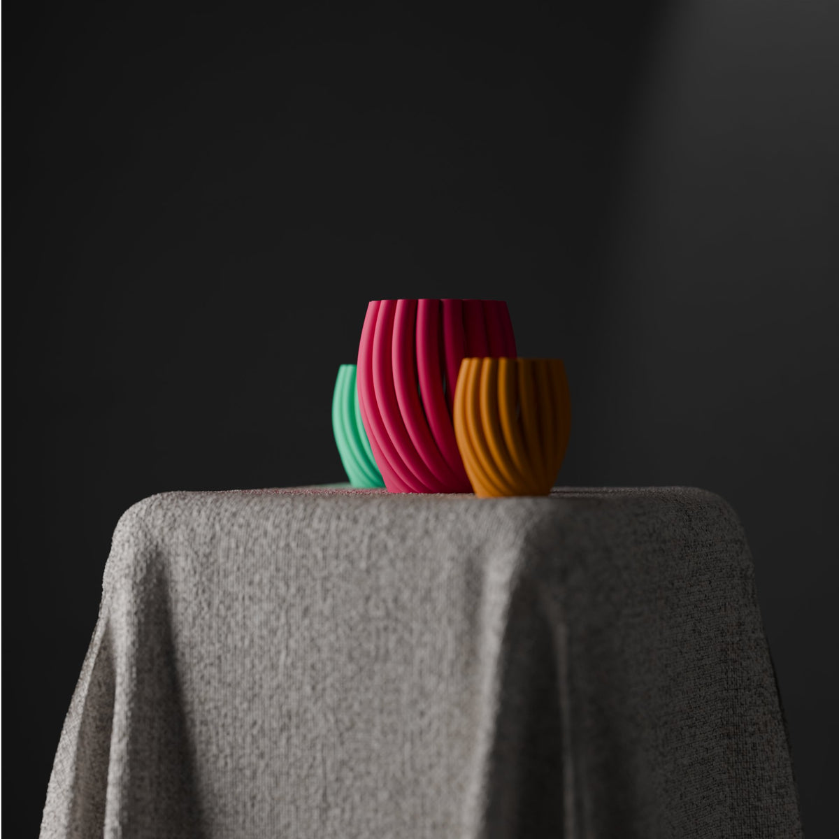 Twist Wave Decorative Vase hot pink mint green mustard yellow three vases overlapping petal-arch spiral ribs draped linen plinth dark studio front wide portrait
