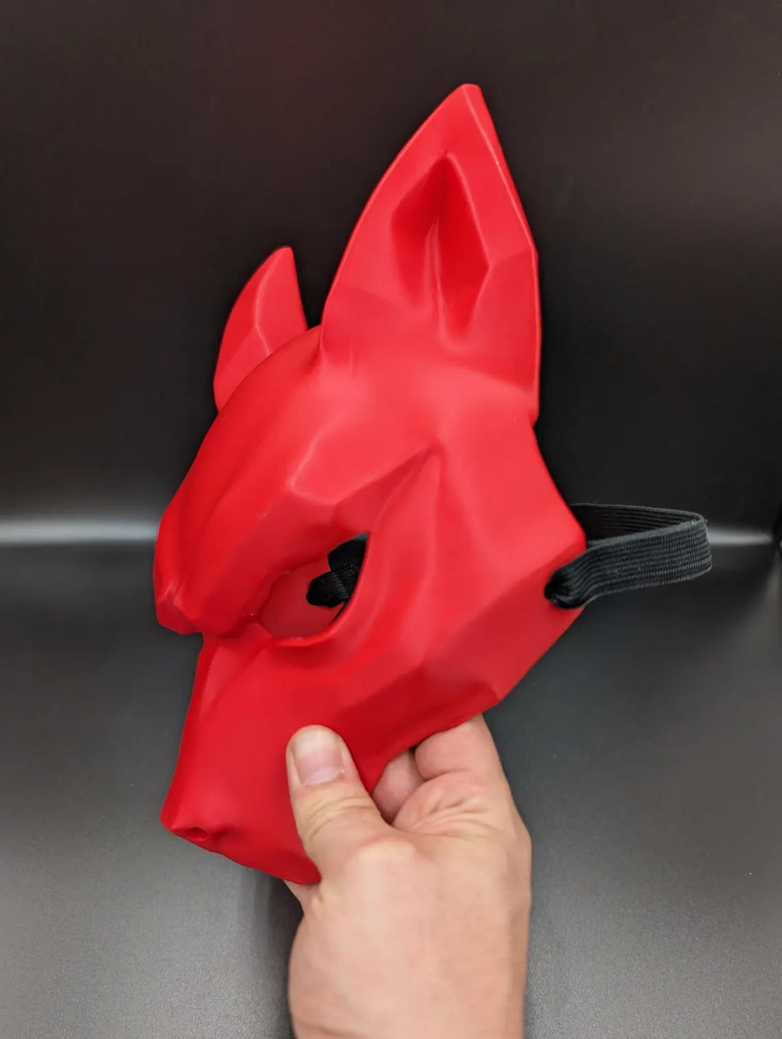 Side angle of the red Kitsune Wolf Mask worn by a model