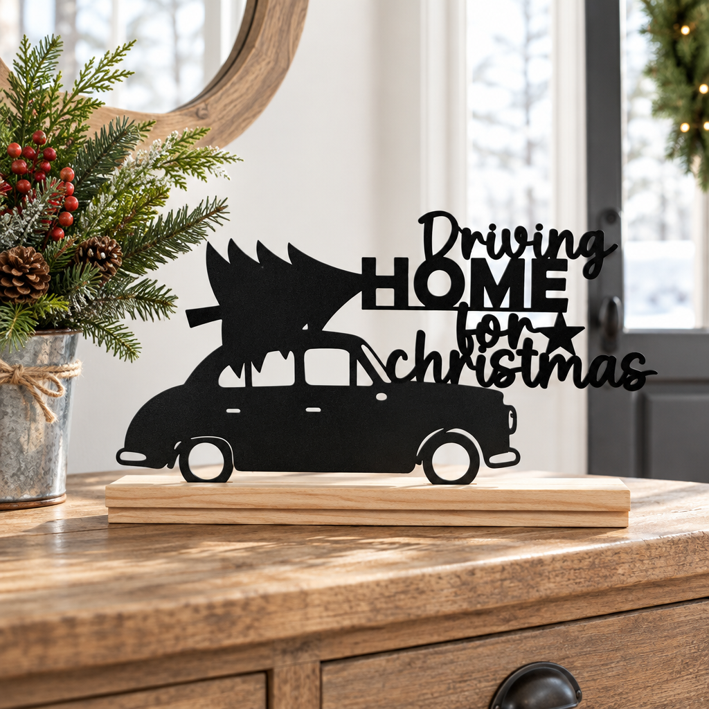 Black Driving Home for Christmas Sign with natural wood base on an entryway console
