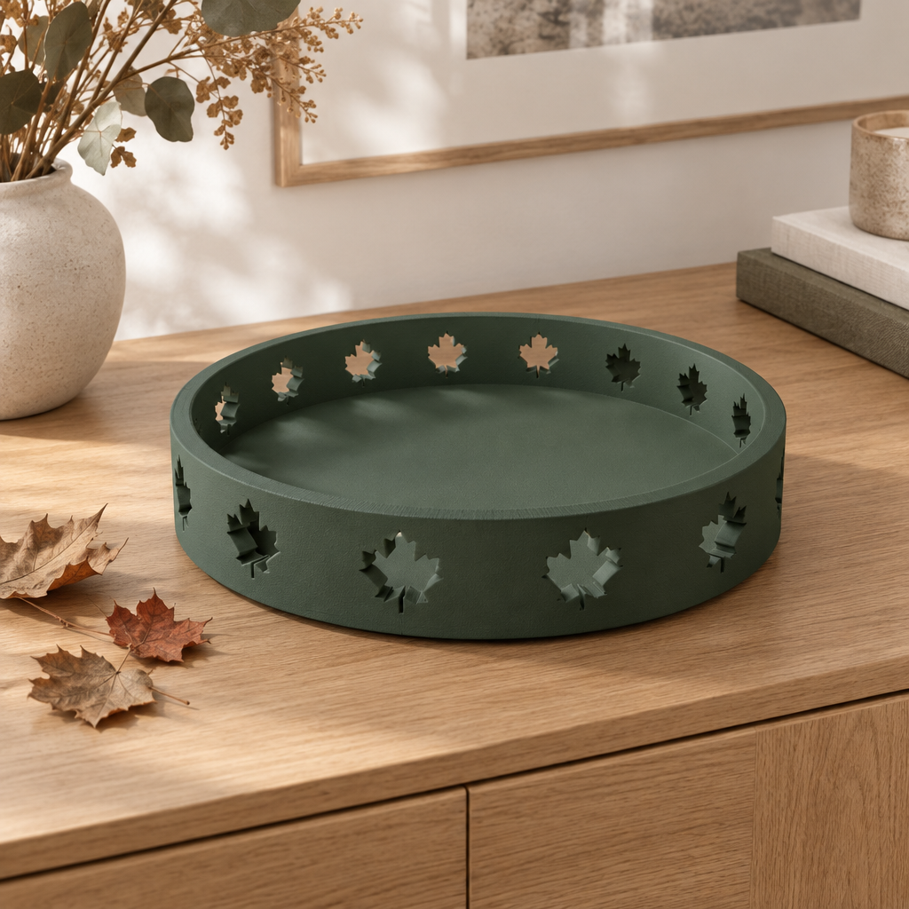 Solid forest-green round Autumn Tray with maple-leaf cutouts on a cream sideboard