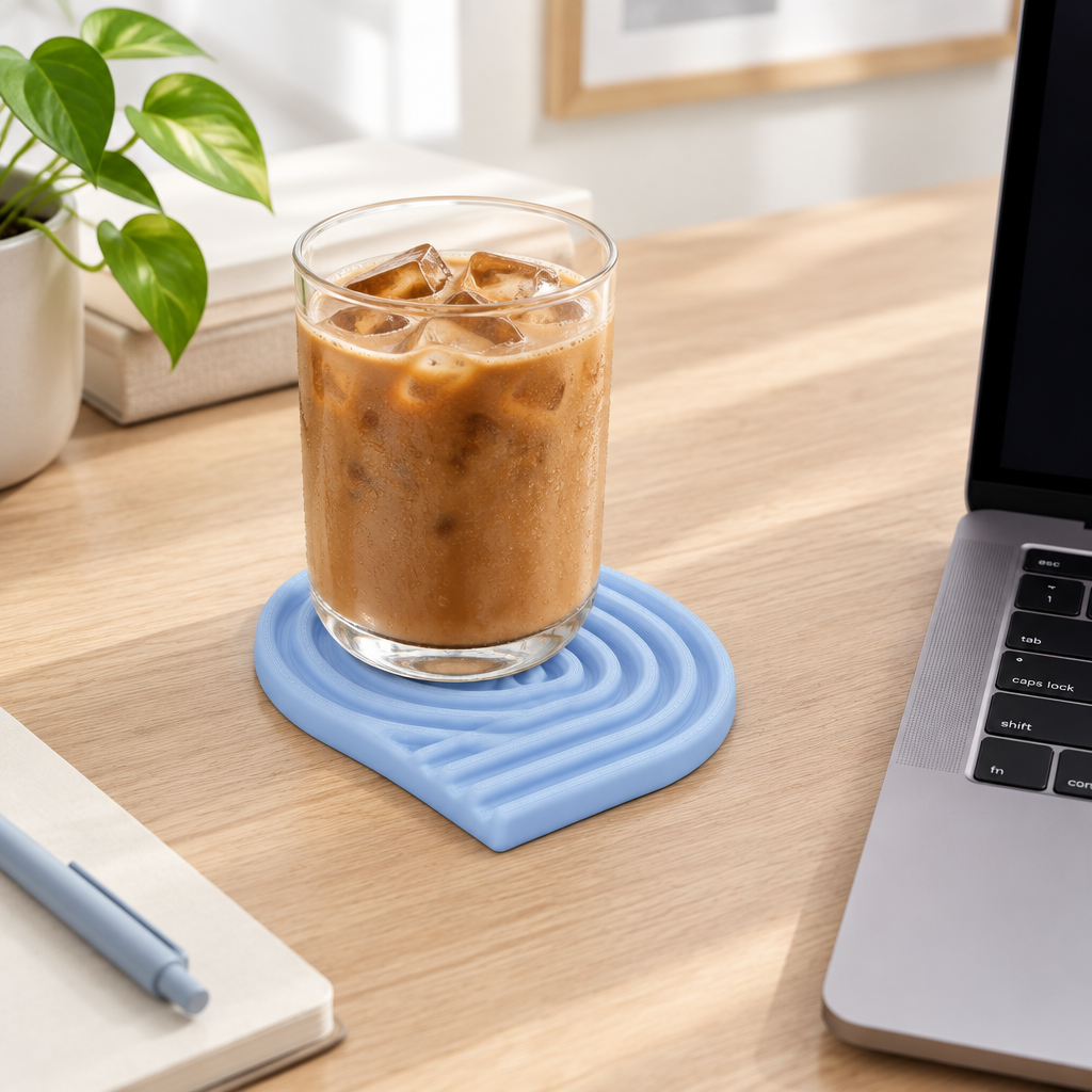 Pastel blue looped coaster with a glass of iced coffee on a home office desk