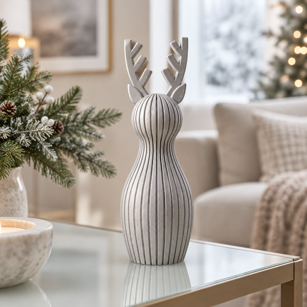 A single silver ribbed reindeer ornament on a pale glass console table with winter greenery