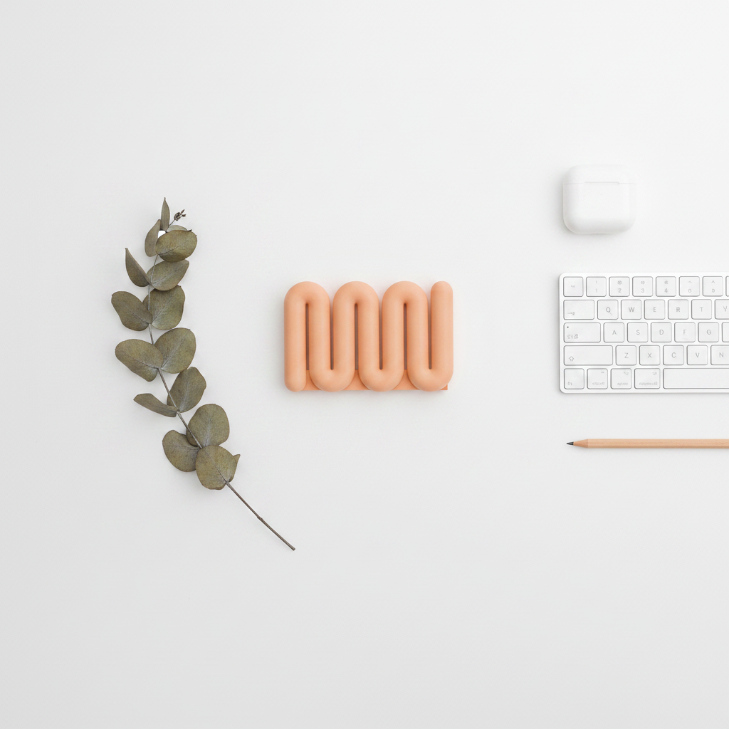 Overhead flatlay of Wibble Vertical Laptop Stand in dusty pink with keyboard and AirPods