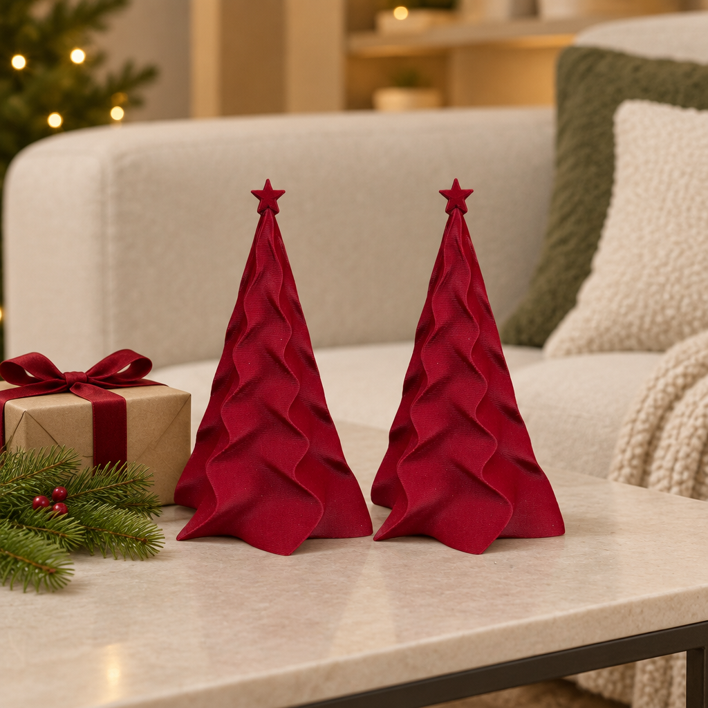 Two matching red folded Christmas trees beside a wrapped gift on a coffee table