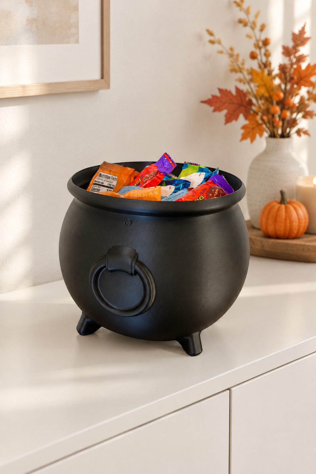 Black cauldron sweet tray on a light hallway console with autumn styling
