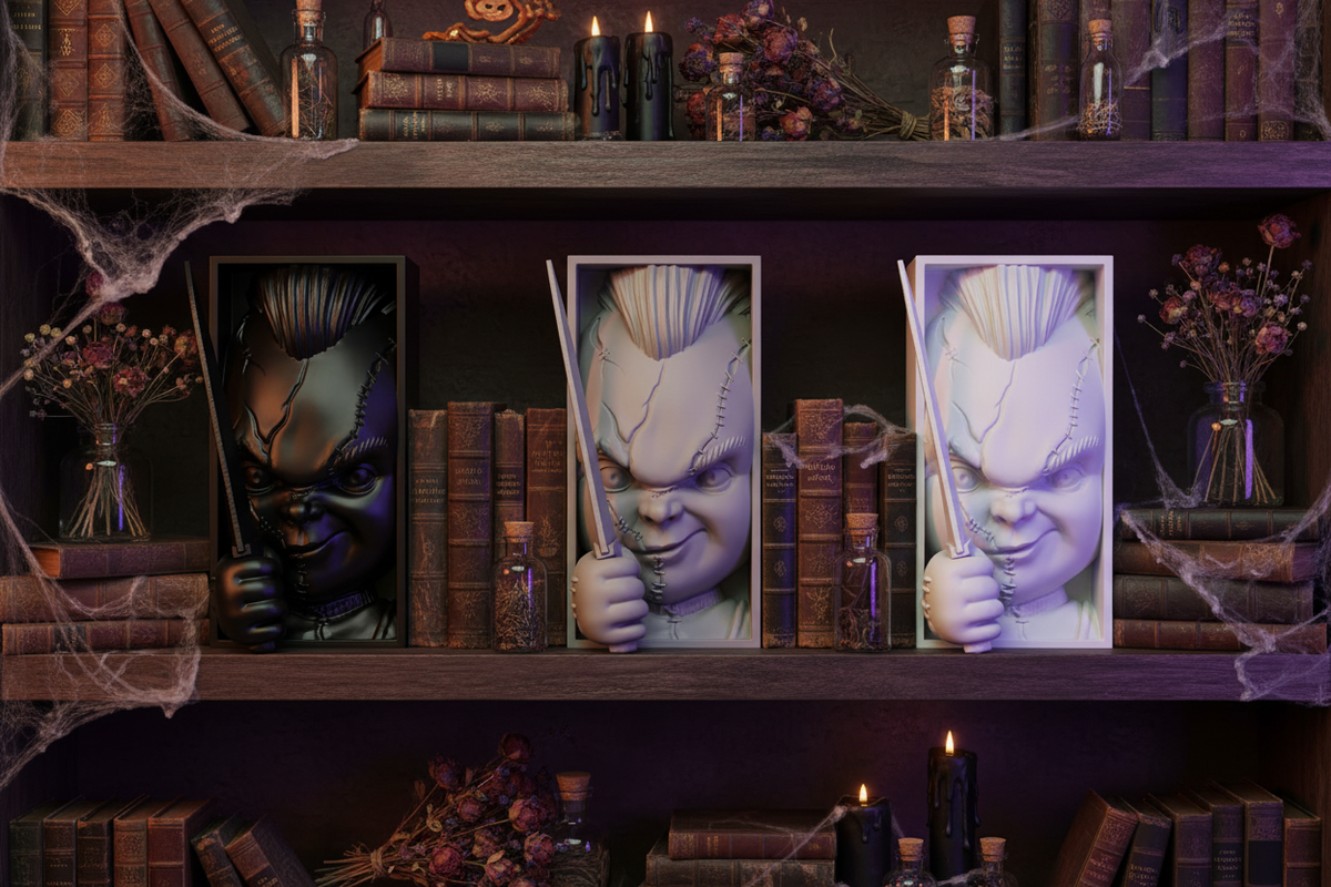 Three Chucky book nook relief sculptures grey white black framed boxes dark wooden shelves vintage hardcover books black candles potion bottles spider webs dried flowers atmospheric moody Halloween shelfie landscape editorial