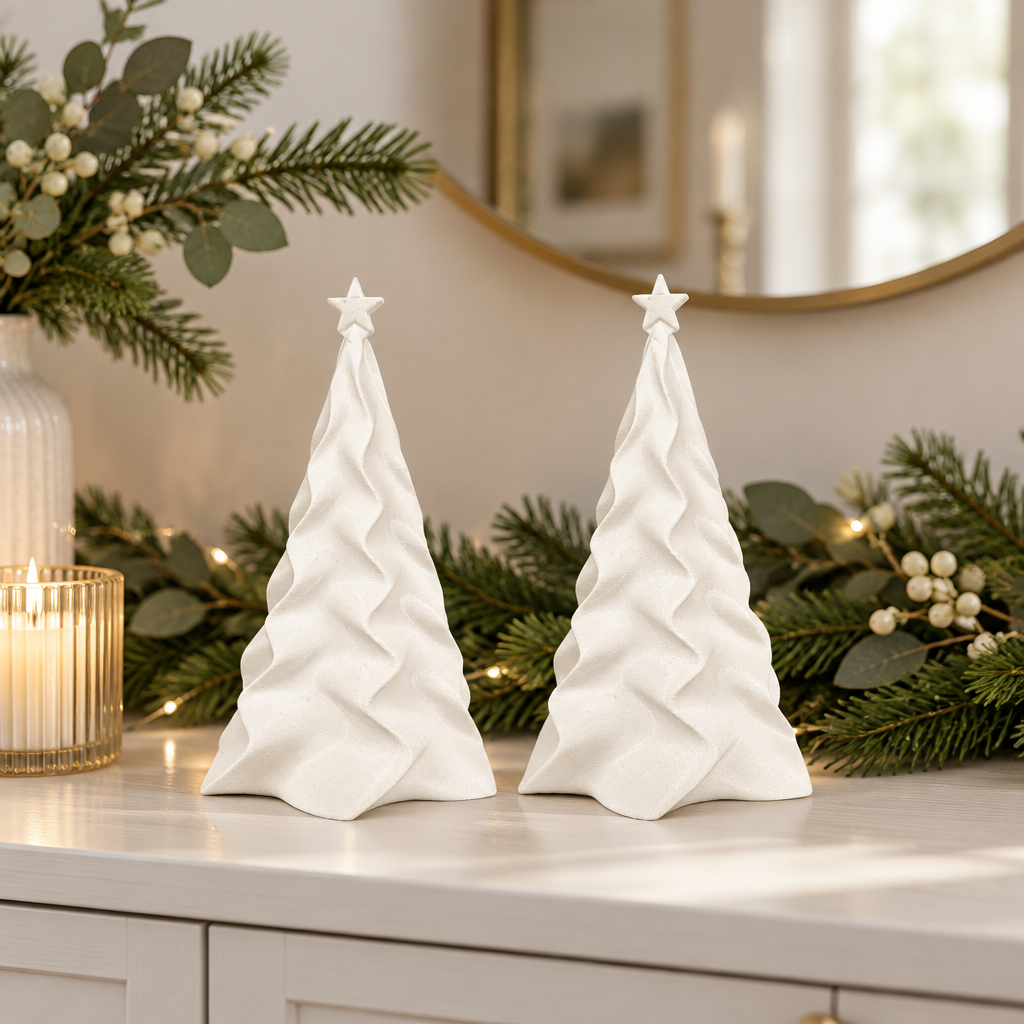 Two matching white folded Christmas trees styled on a bright dining sideboard