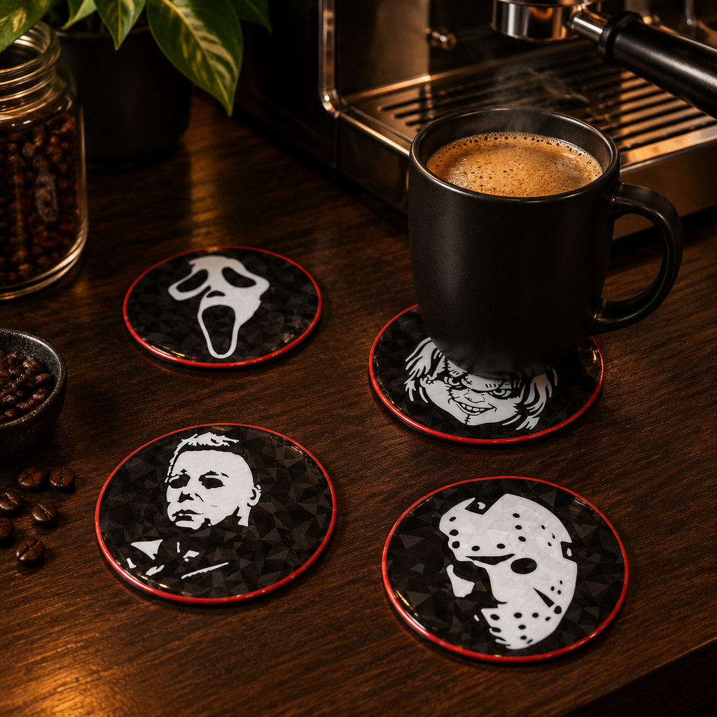 Four black, white and red horror character coasters beside an espresso machine