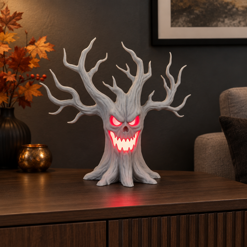 Grey laughing tree tealight holder displayed on a living-room console with autumn leaves