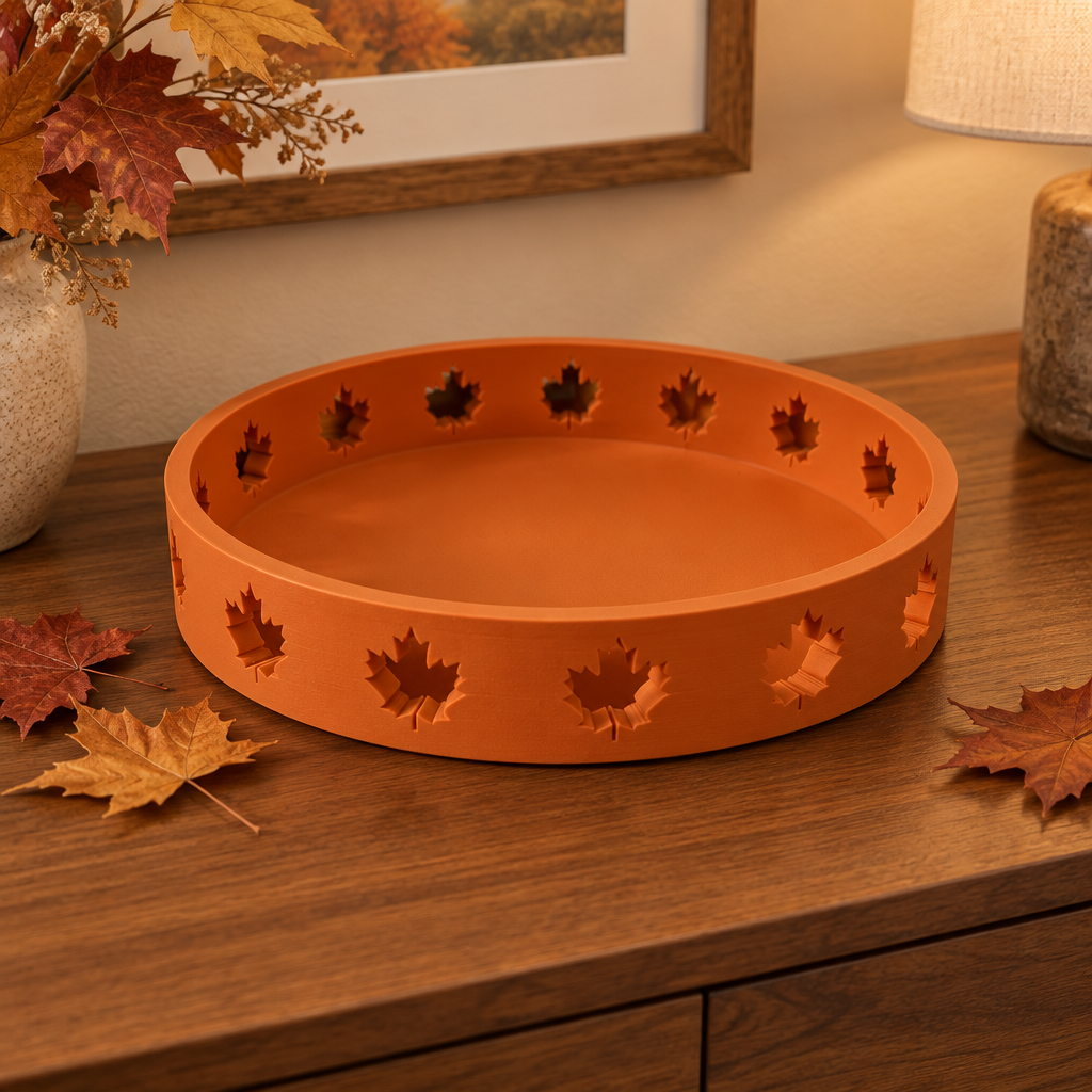 Solid orange round Autumn Tray with maple-leaf cutouts on an autumn console table