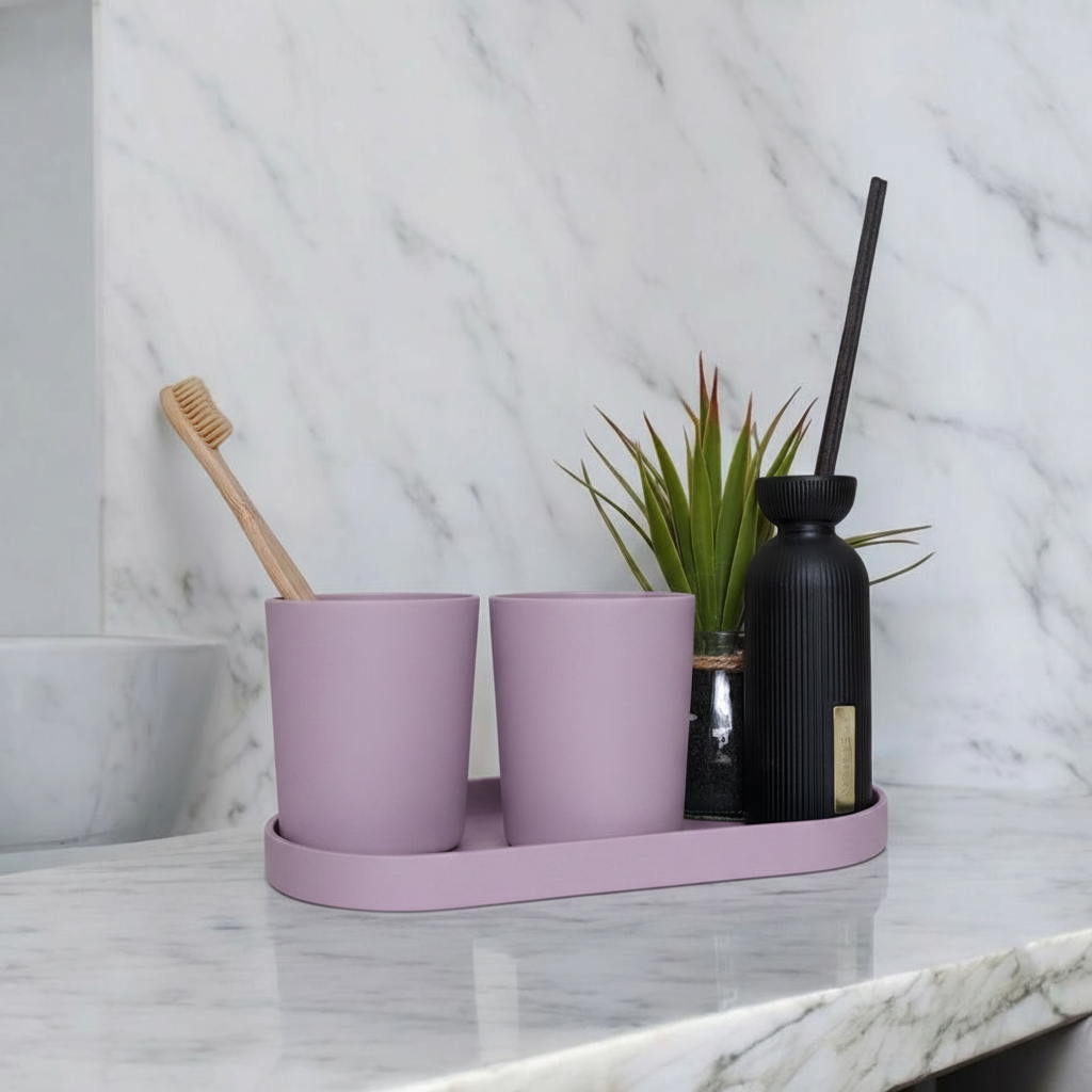 Lavender purple calm sink set on marble bathroom counter with bamboo toothbrushes, perfume bottle and plant