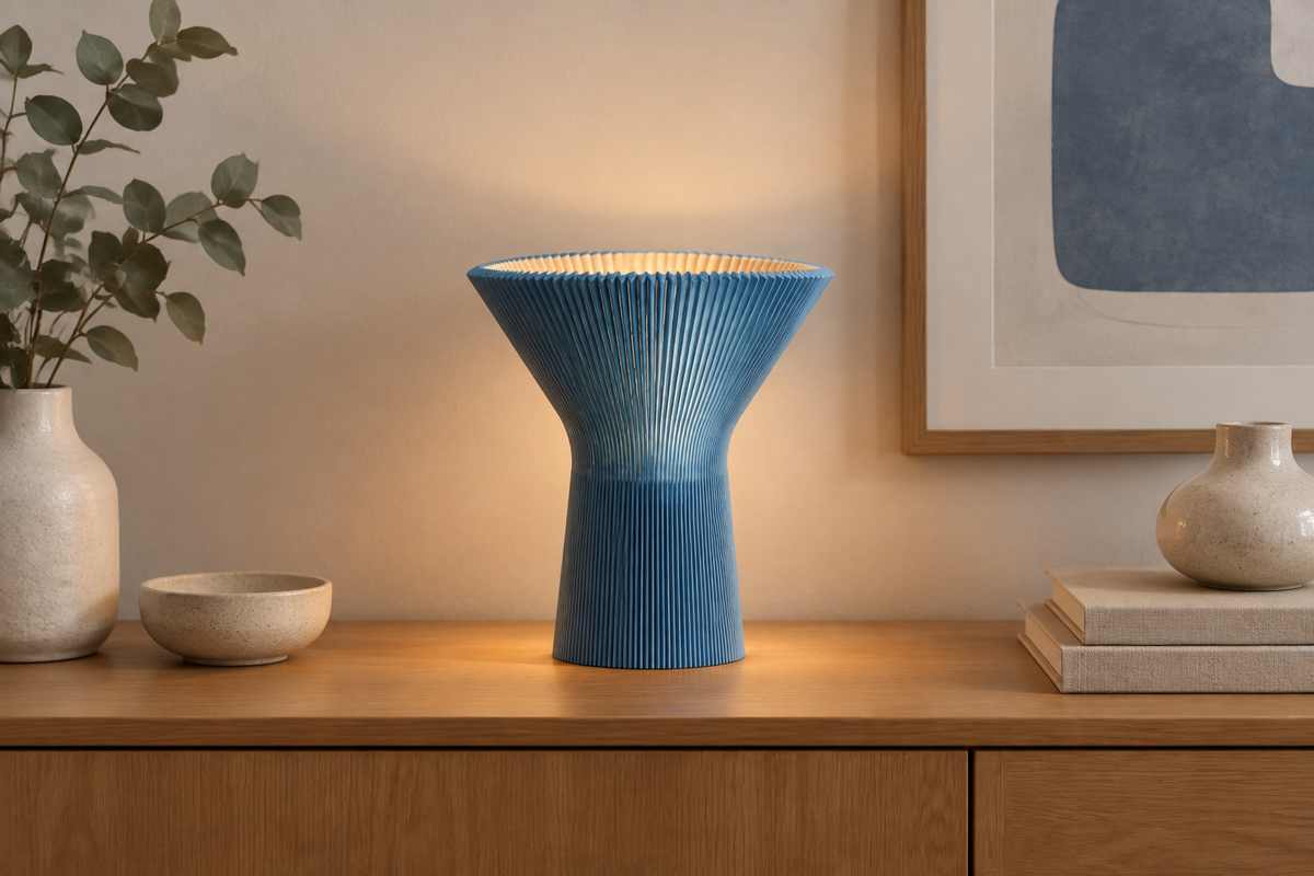 Blue inverted funnel lamp displayed on a contemporary sideboard.