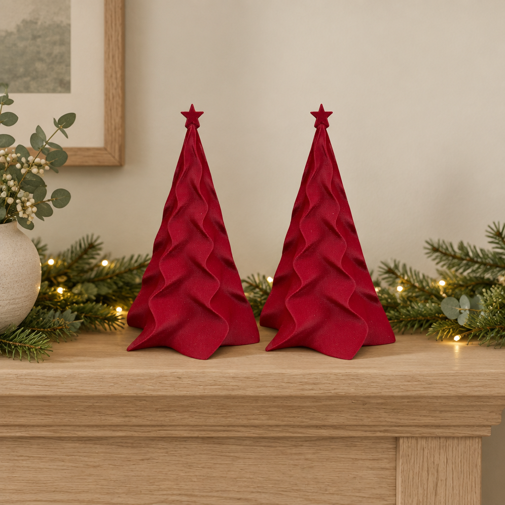 Two matching red folded Christmas trees with red star toppers styled together on a mantel