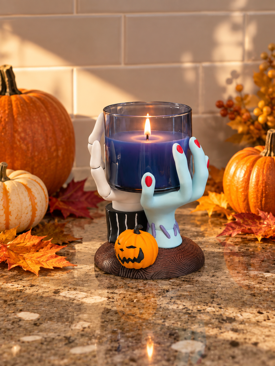 Hands Candle Holder with a blue candle and pumpkin accent styled on a wooden surface