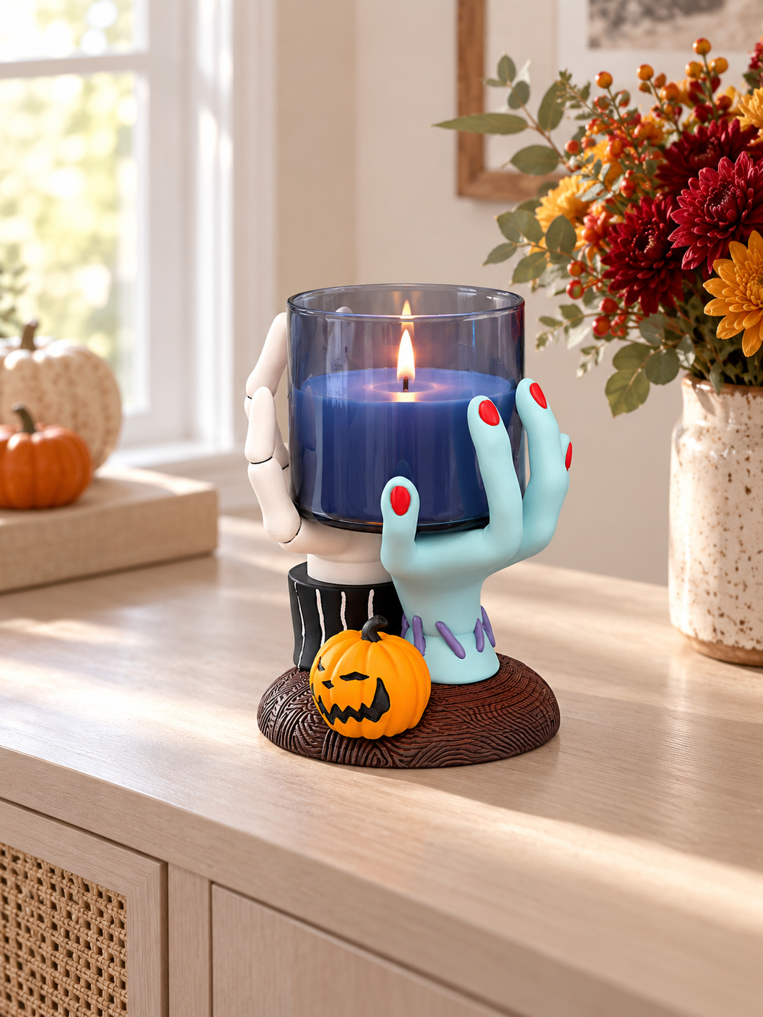 Hands Candle Holder with warm candlelight displayed on a wooden mantel beside autumn foliage