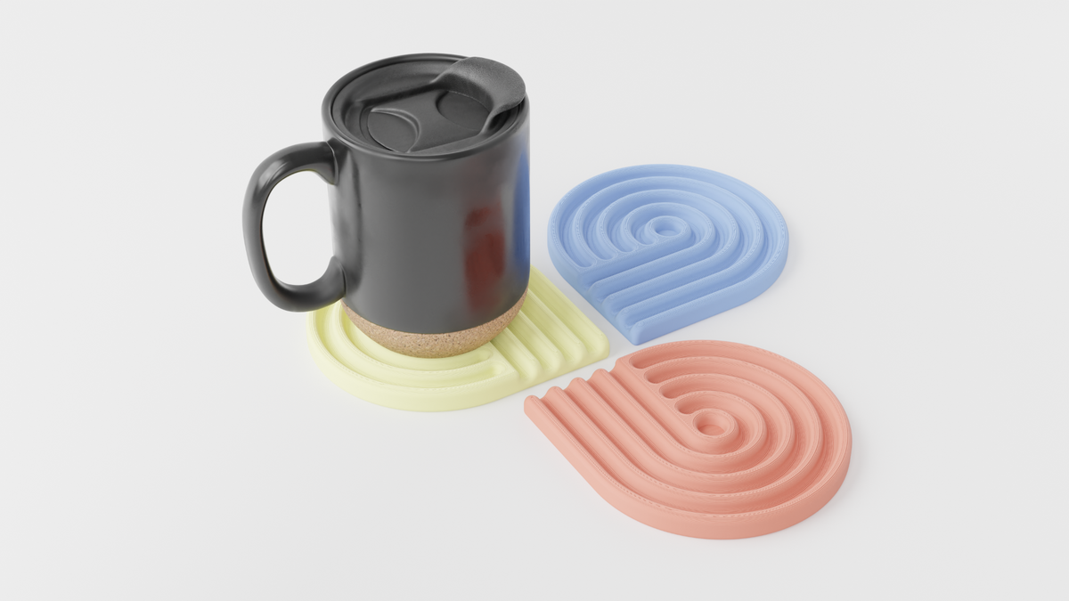 Black mug resting on a pastel yellow looped coaster beside a blue and a coral coaster