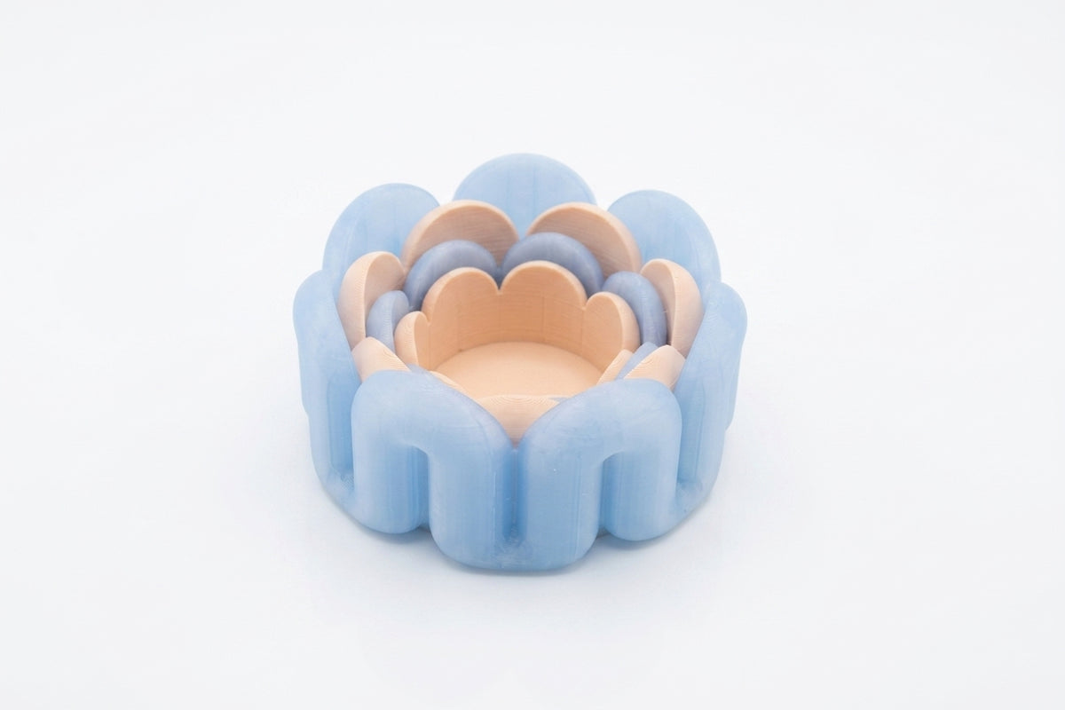 Overhead flat lay blue wibble nested trays on kraft paper with eucalyptus marble fragments and copper tray
