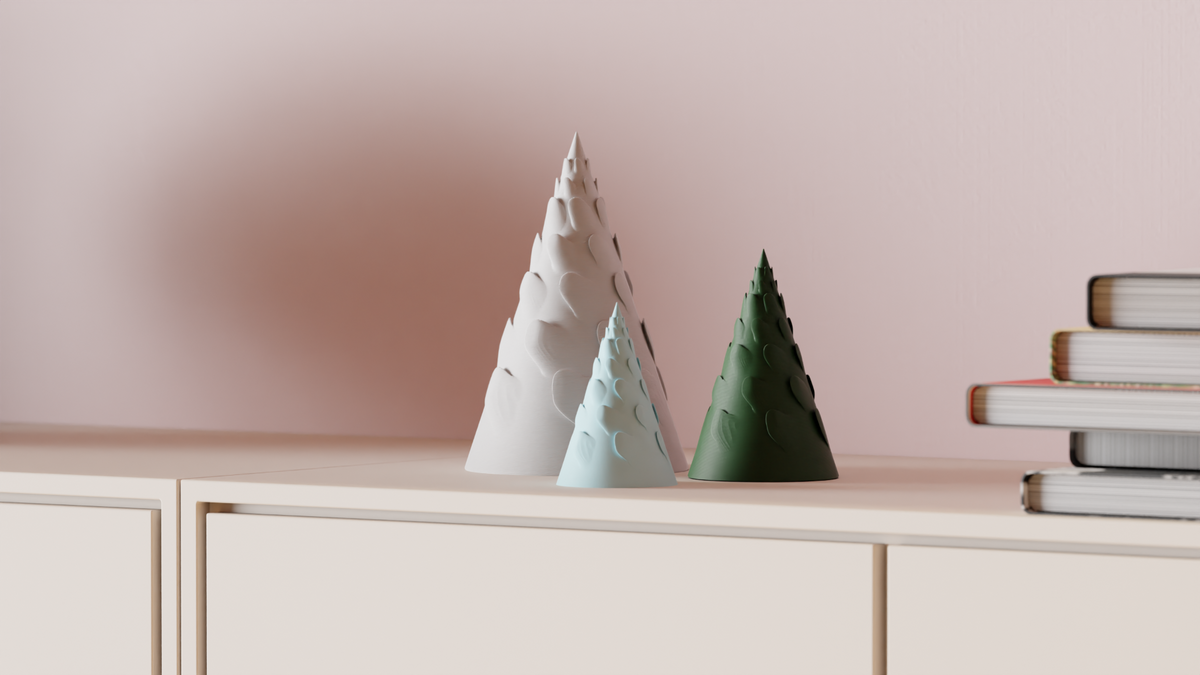 Three Spiral Branch Christmas Trees styled on a shelf beside books