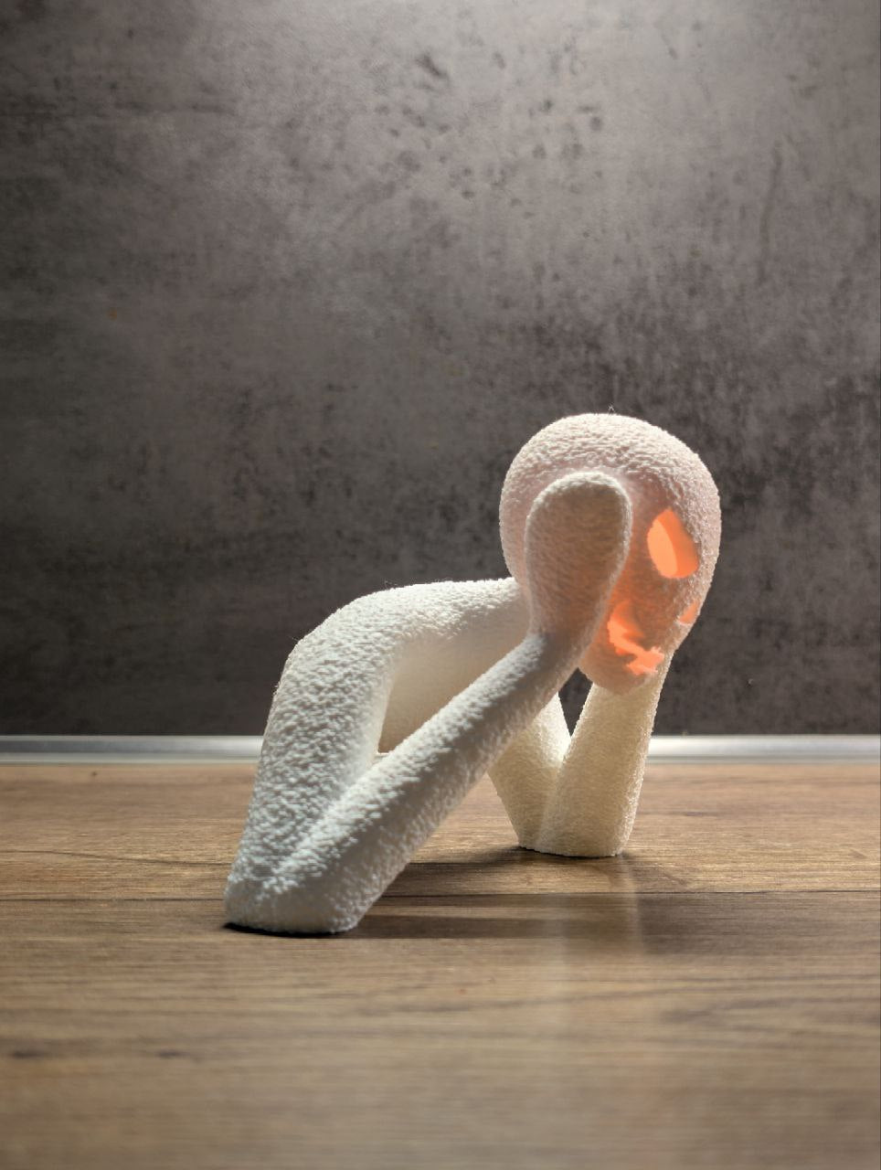 Close tabletop view of the white textured Halloween lamp with warm orange facial glow
