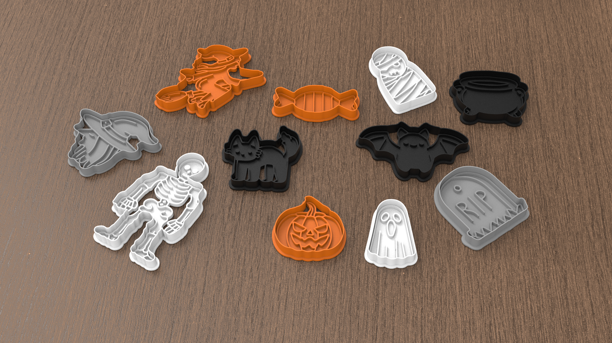 Assorted Halloween cookie cutters shown on a wooden surface